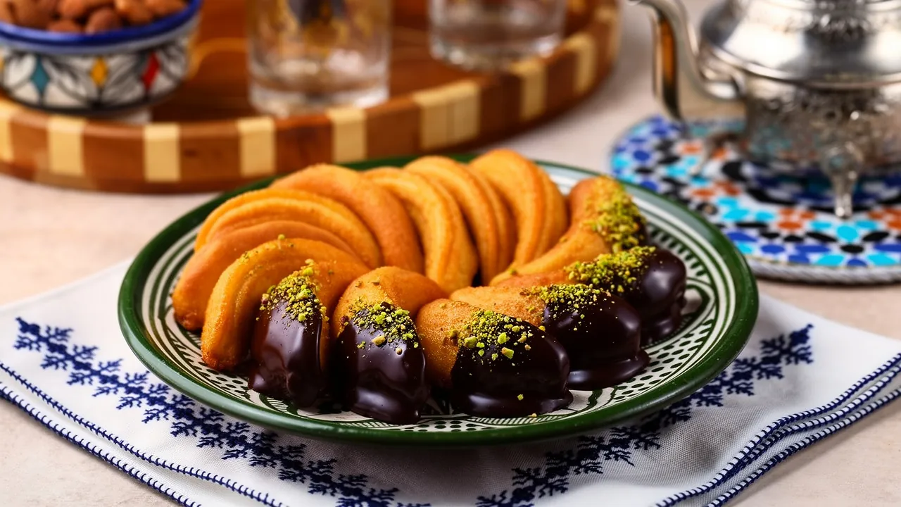 Cornes de gazelle marocaines saupoudrées de sucre glace, garnies d’amandes et délicatement façonnées